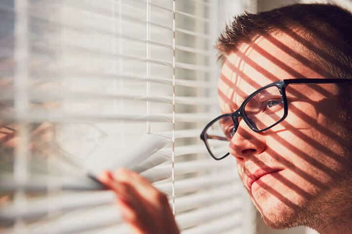 curious man looking through a jalousie curious man looking through a jalousie